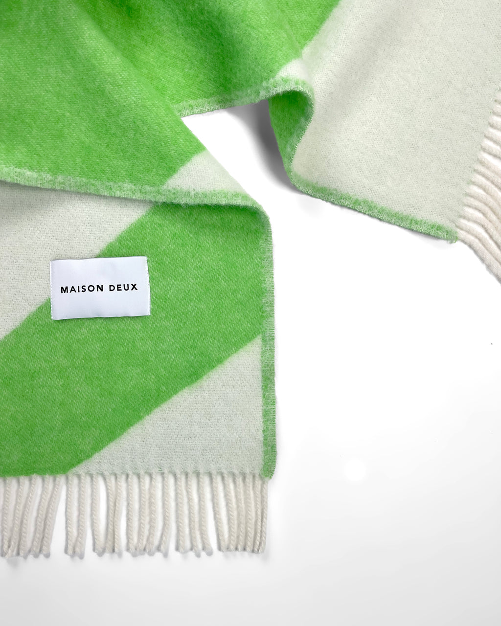 Close-up of apple green and white swirl wool throw with fringe
