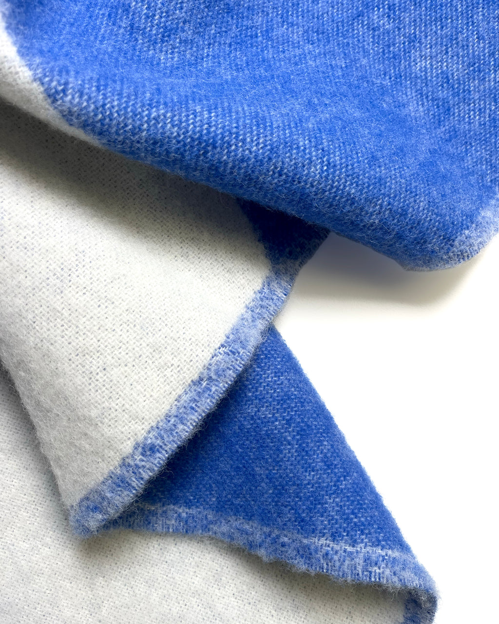 Close-up of cobalt blue and white swirl wool throw with fringe
