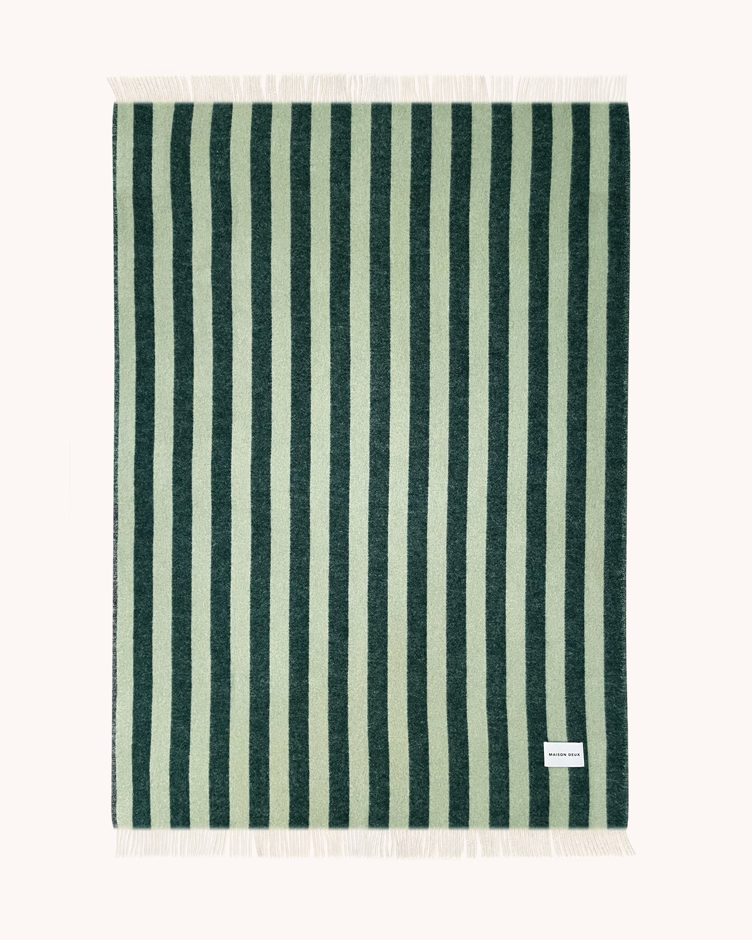 Dark green and sage striped wool throw shown flat with fringe detail
