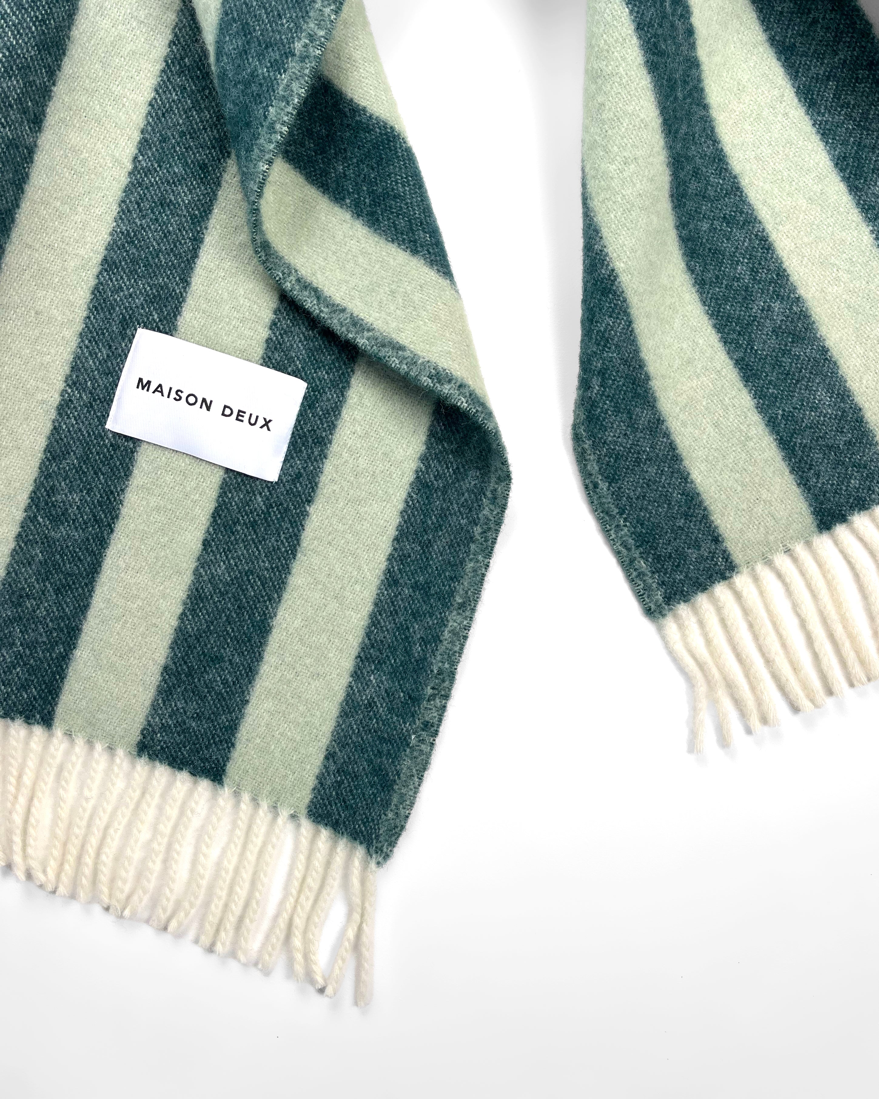 Close-up of dark green and sage striped wool throw with fringe
