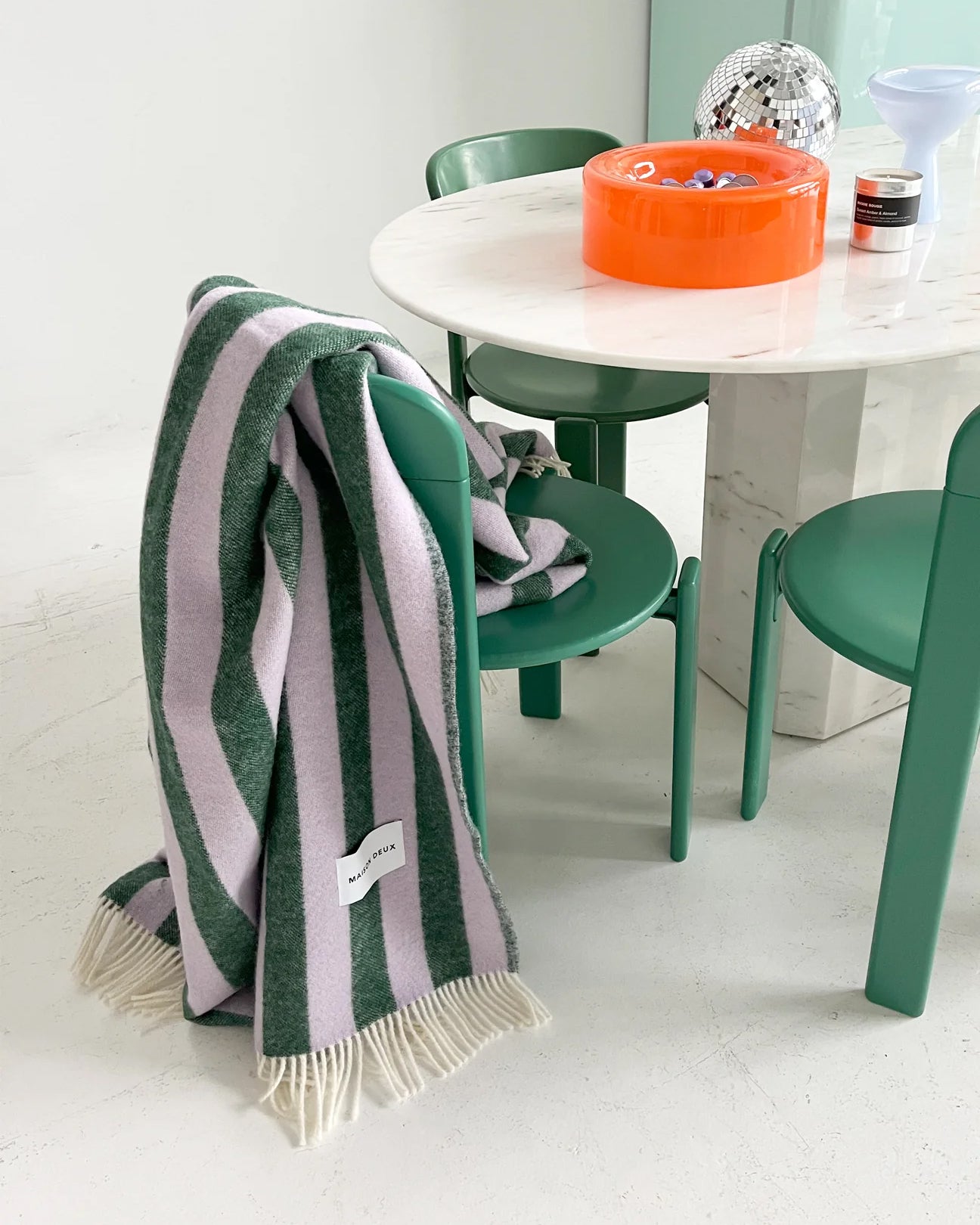 Lilac and green striped wool throw draped over dining chair
