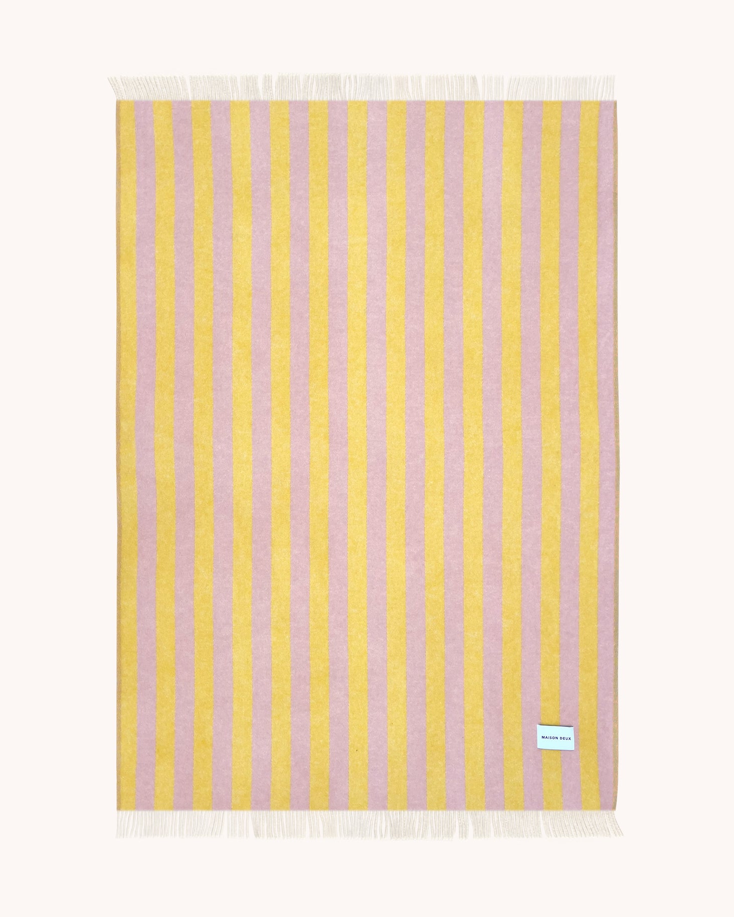 Pink and yellow striped wool throw shown flat
