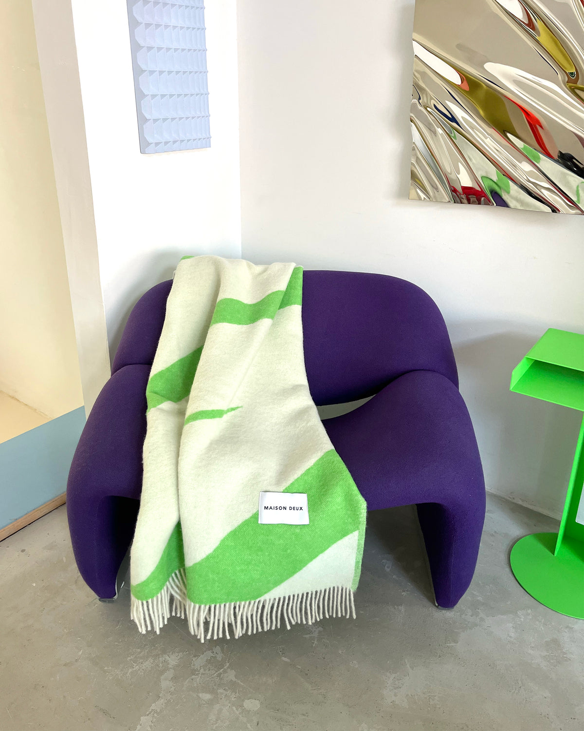 Apple green and white swirl wool plaid draped over chairs in styled room
