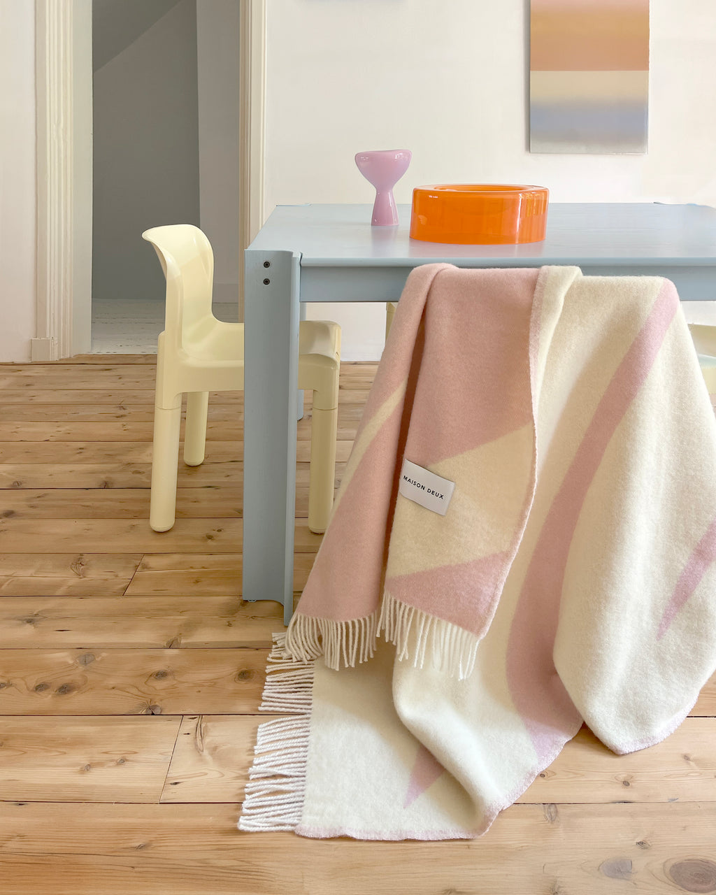 Pink and butter yellow swirl wool plaid draped over table
