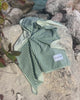 Video of sage green striped beach towel in outdoor beach setting