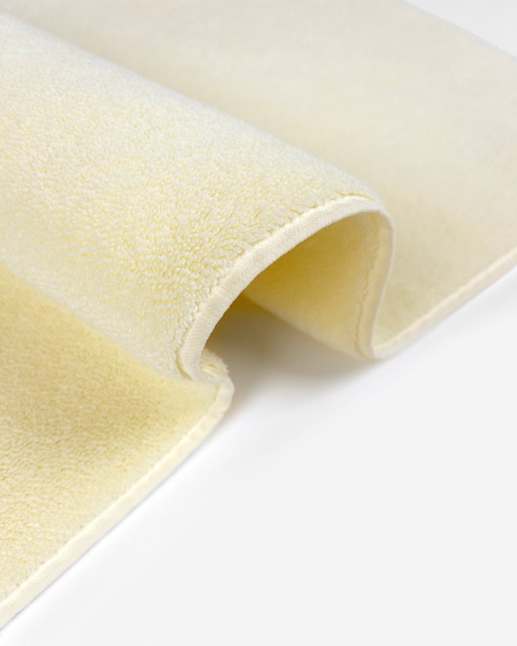 Close-up of dense GOTS-certified terry weave, butter yellow bath mat