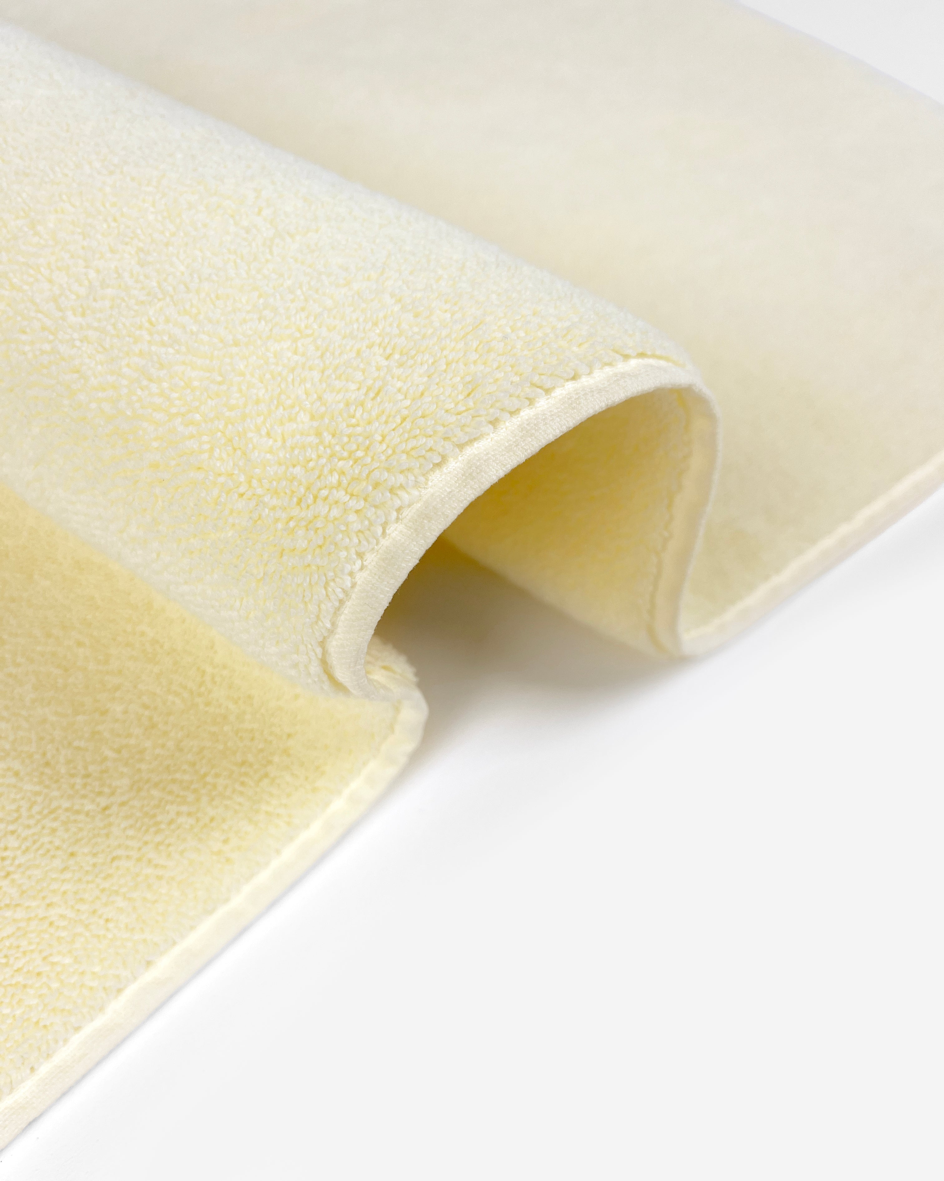 Close-up of dense GOTS-certified terry weave, butter yellow bath mat