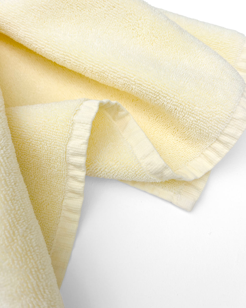 Close-up of dense GOTS-certified organic cotton terry weave, butter yellow