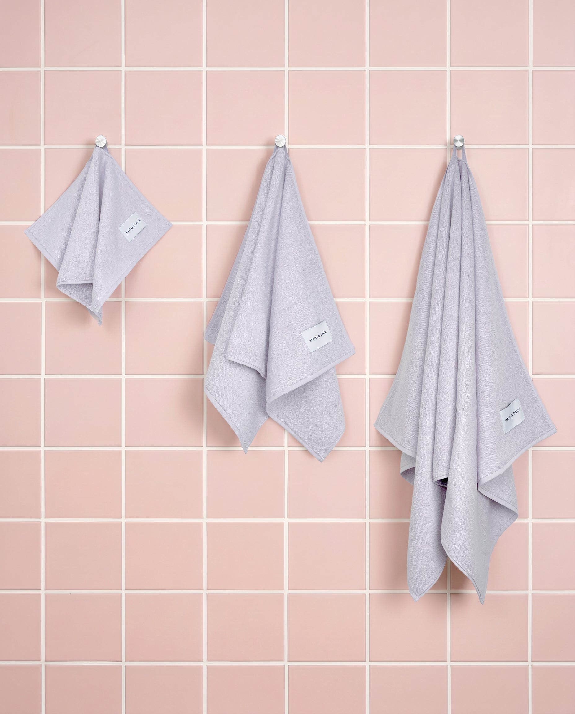 Solid lilac organic cotton towels shown in guest, hand and bath sizes