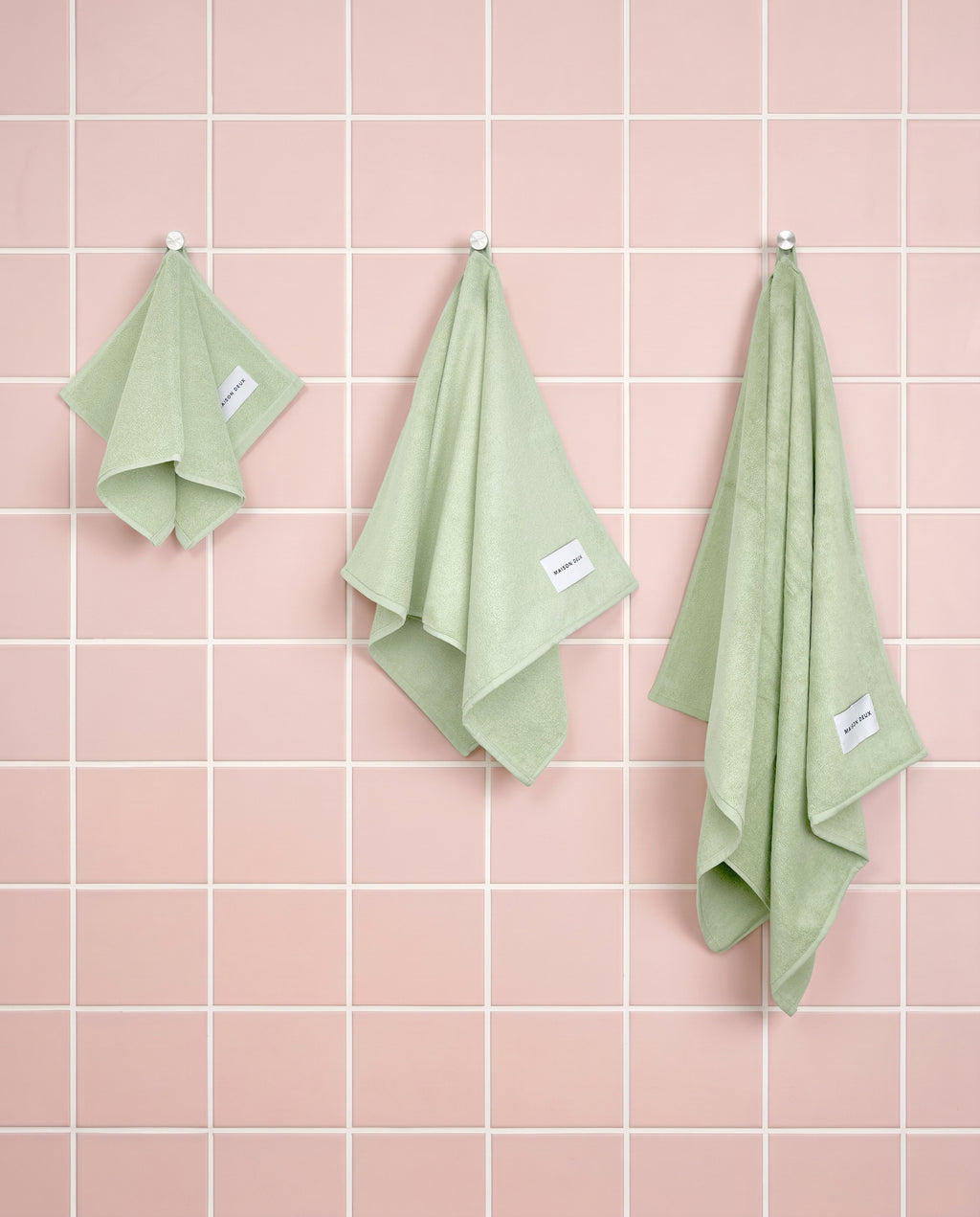 Solid sage green organic cotton towels shown in guest, hand and bath sizes