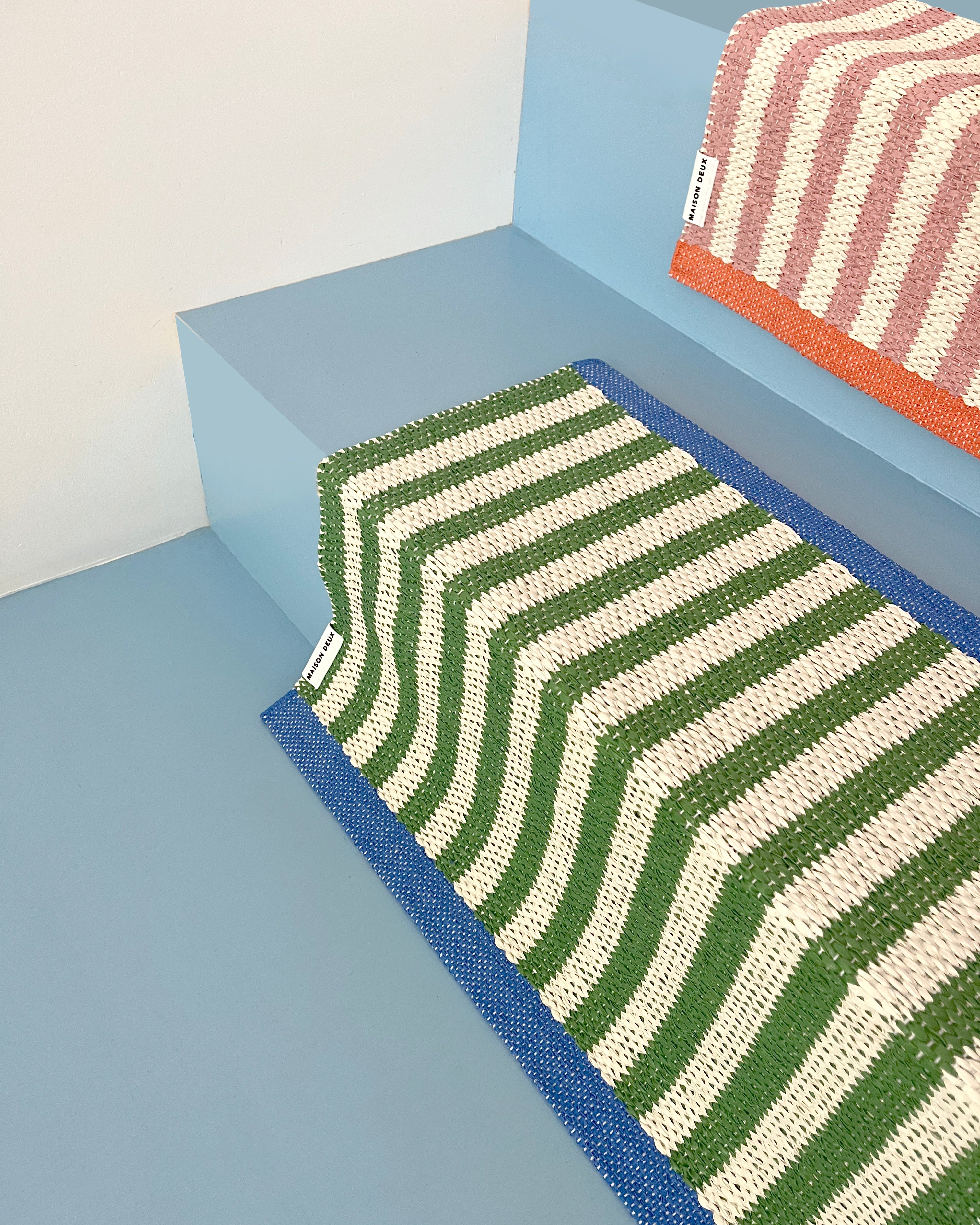 White and green striped doormat styled together with pink and white striped doormat