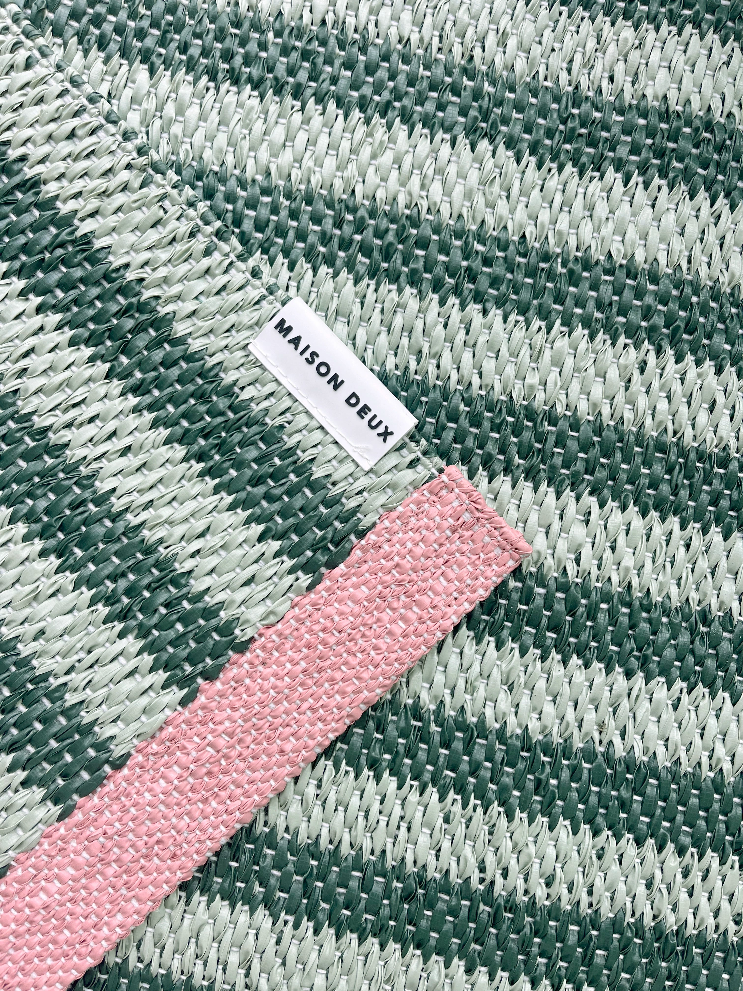 Close-up of Swedish woven jacquard stripe pattern, green and light green with pink border
