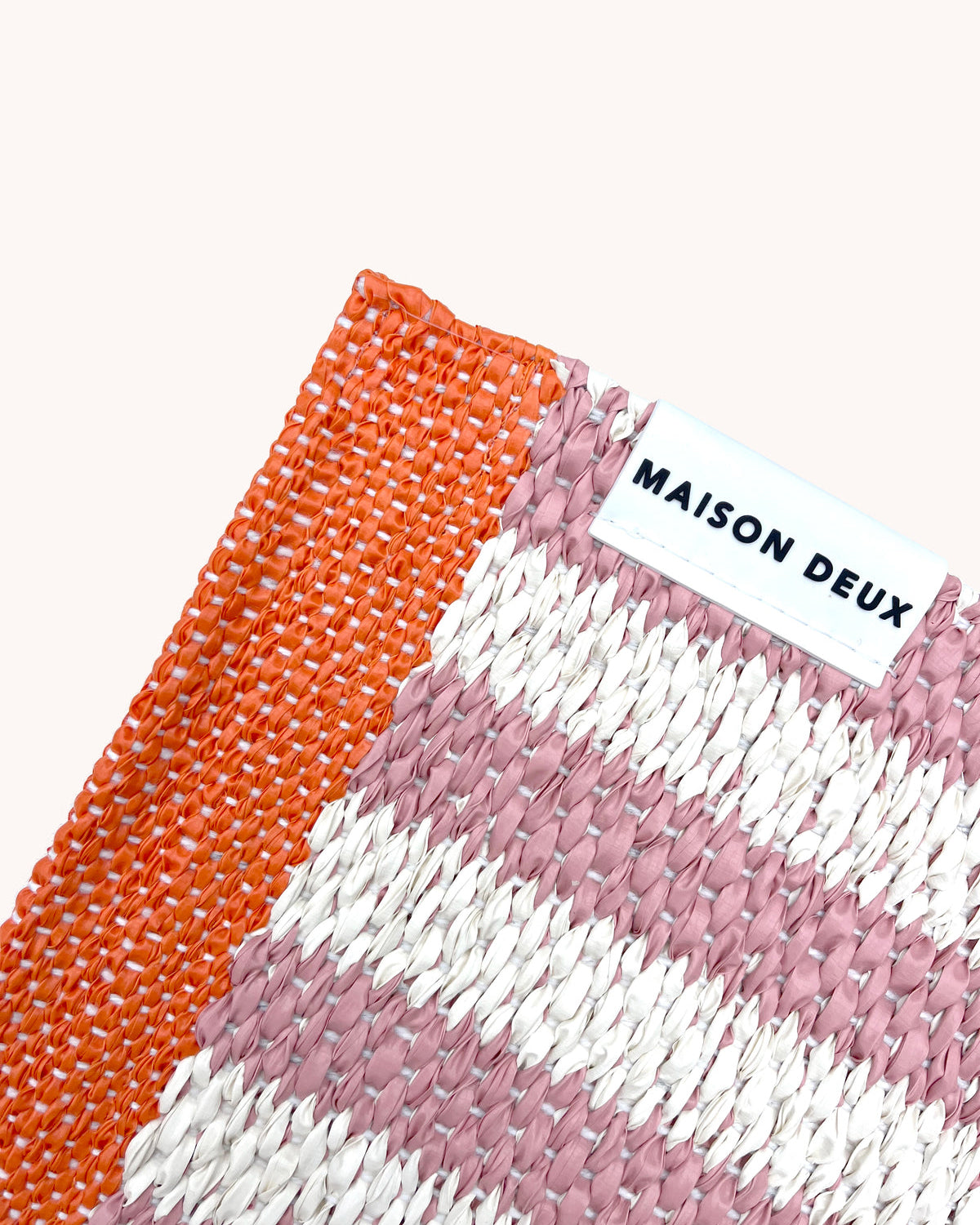 Close-up of Swedish woven jacquard stripe pattern, pink and white with coral border