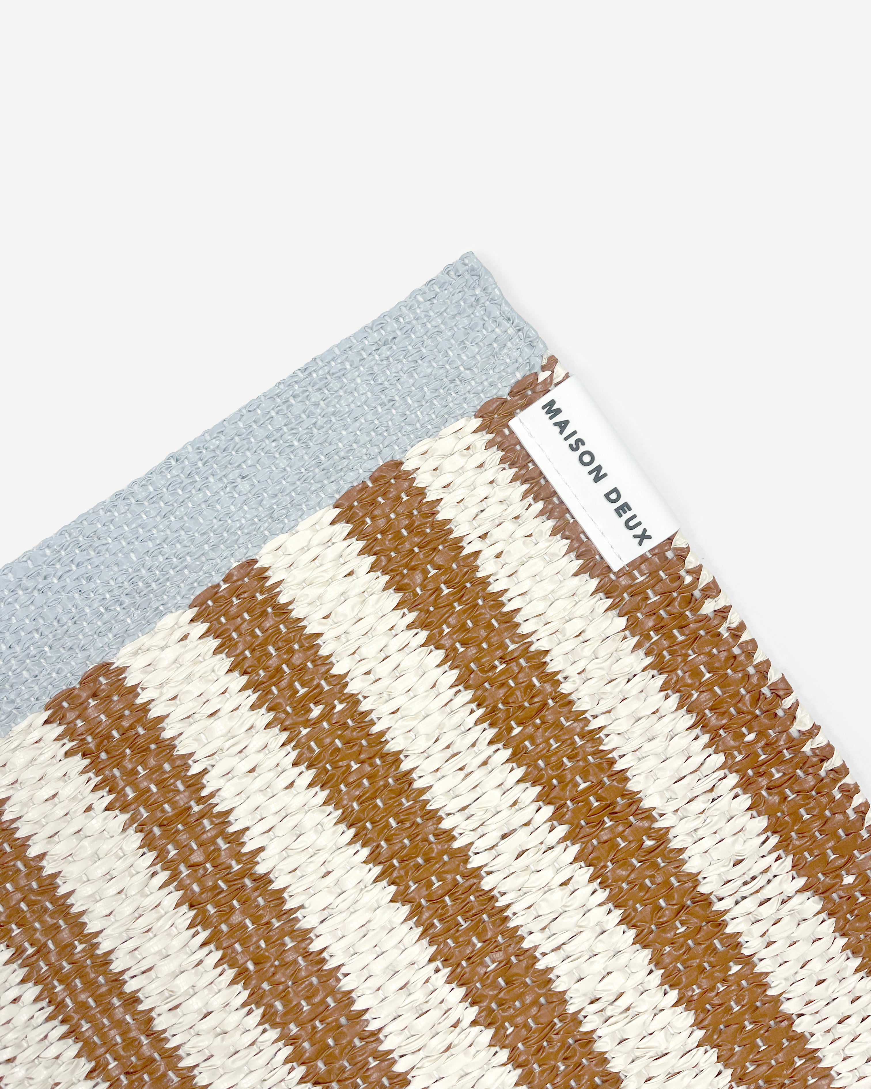 Close-up of Swedish woven jacquard stripe pattern, terracotta orange and white with blue border