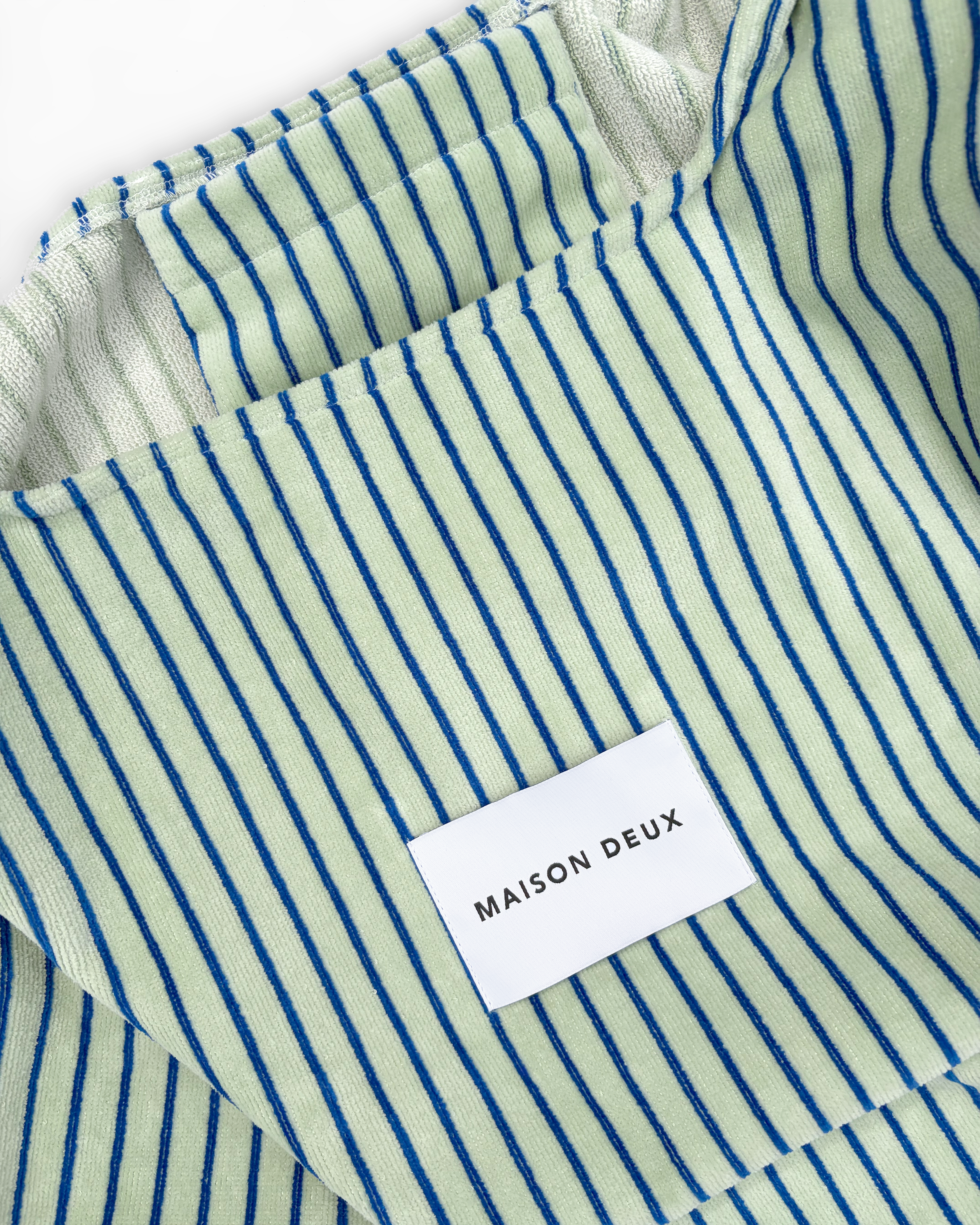 Close-up of sage and cobalt blue striped terry bag interior lining