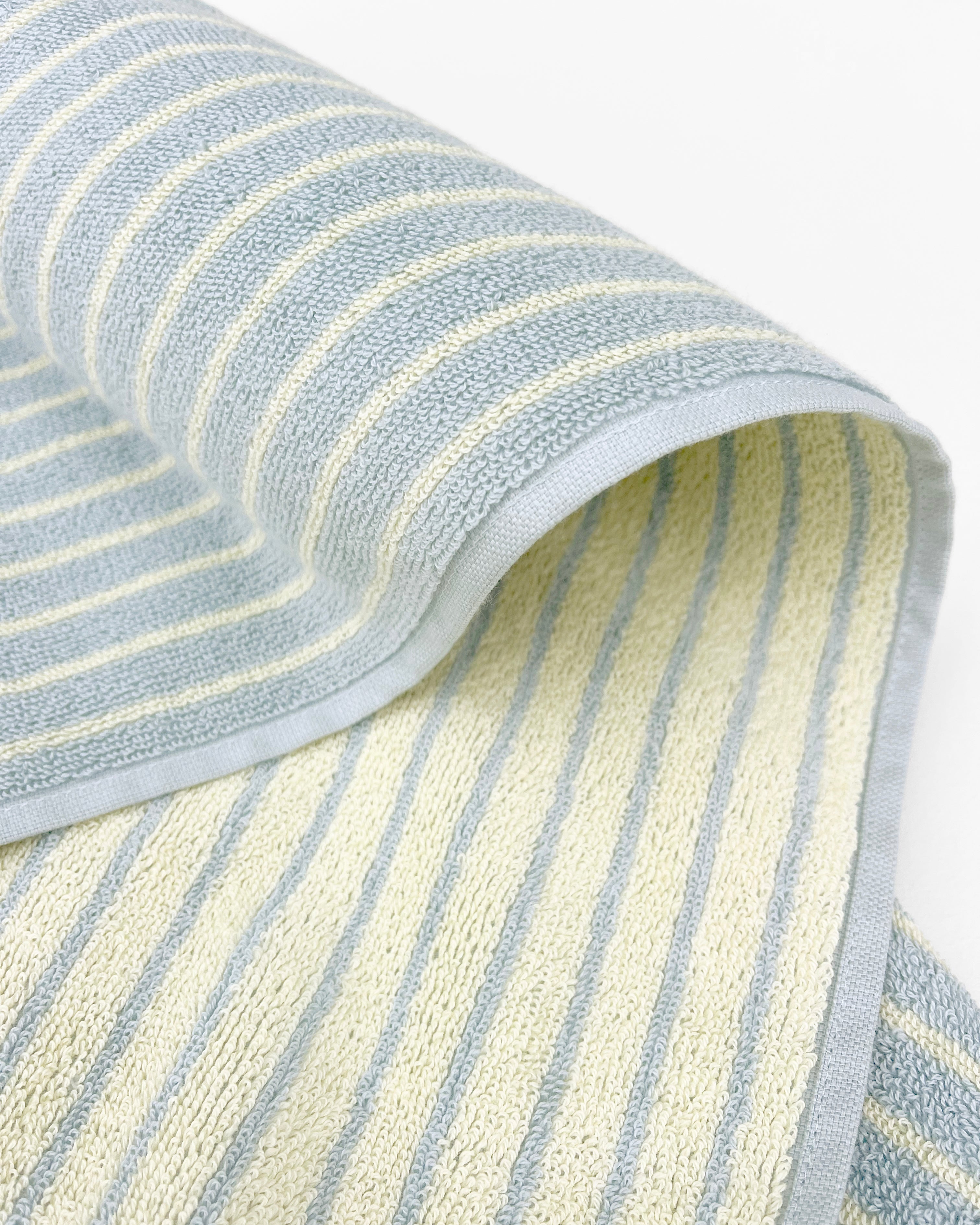 Close-up of dense terry weave on blue and butter yellow striped towel