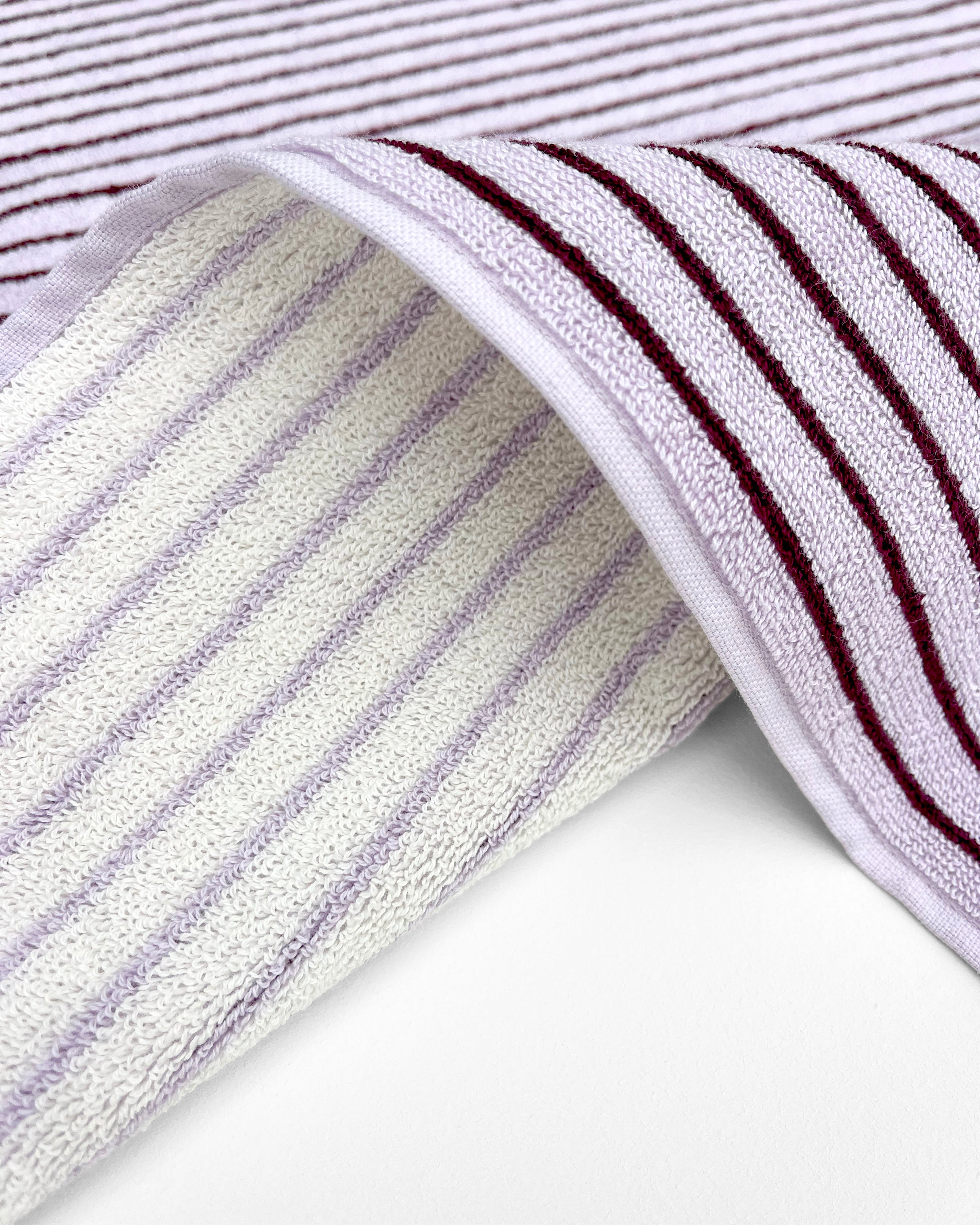 Close-up of dense terry weave on lilac and bordeaux striped towel