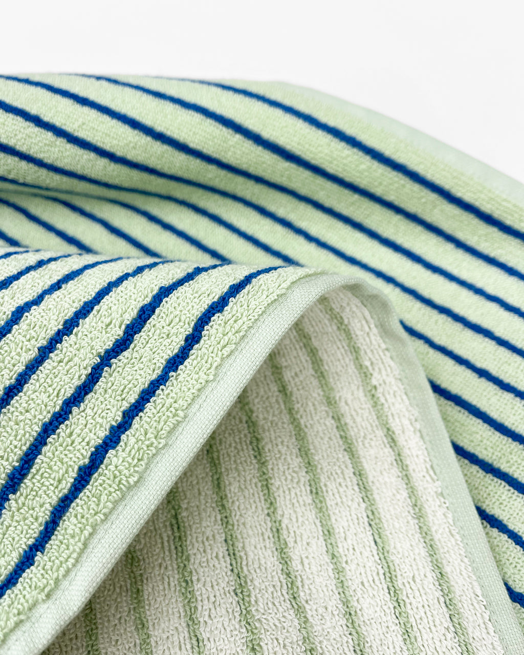 Close-up of dense terry weave on sage cobalt blue striped towel
