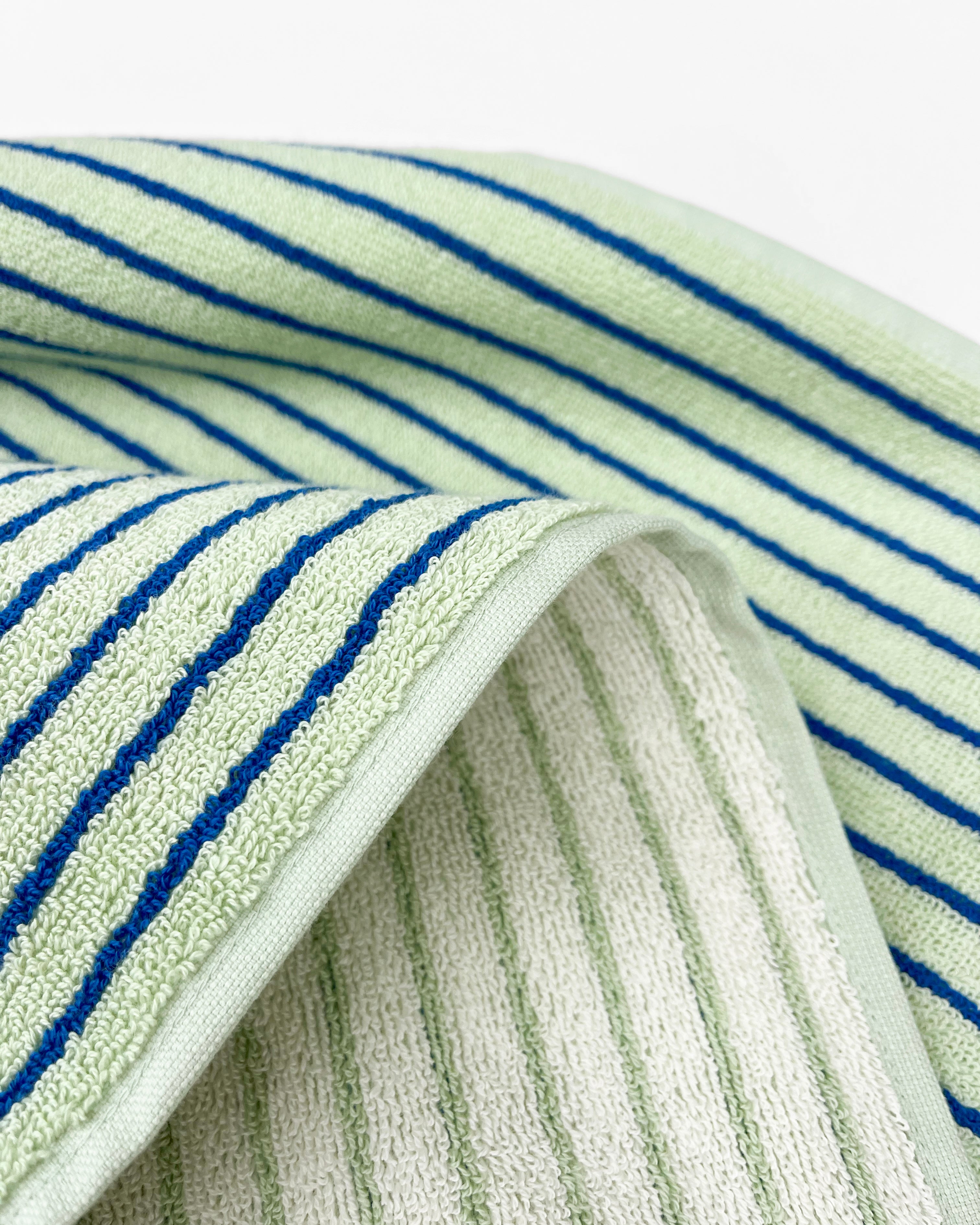 Close-up of dense terry weave on sage cobalt blue striped towel