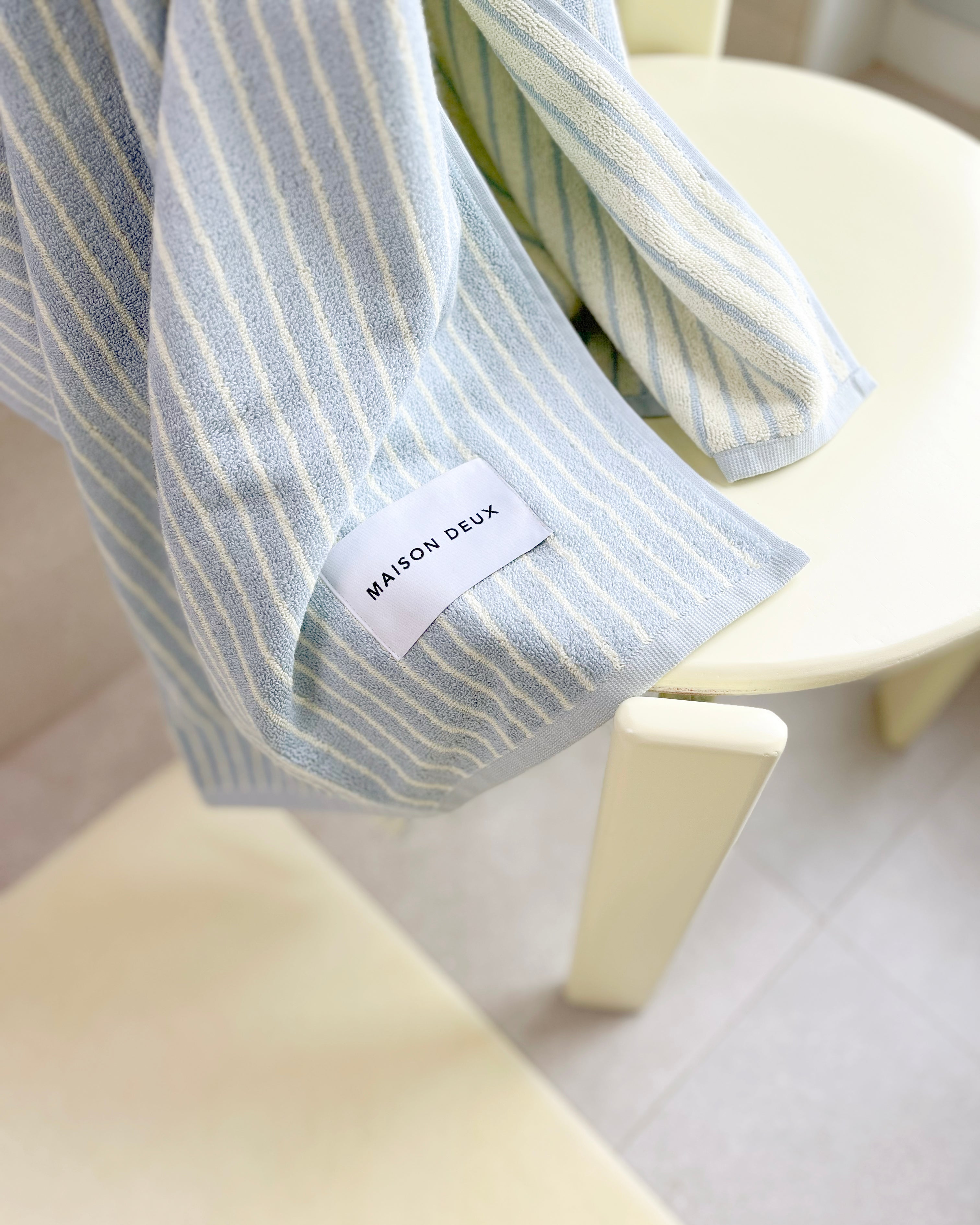 Blue and butter yellow striped towel draped over chair