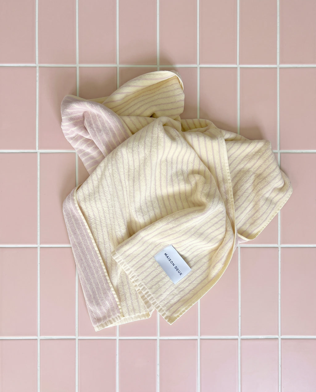 Butter yellow and pink striped towel styled in twisted wrap