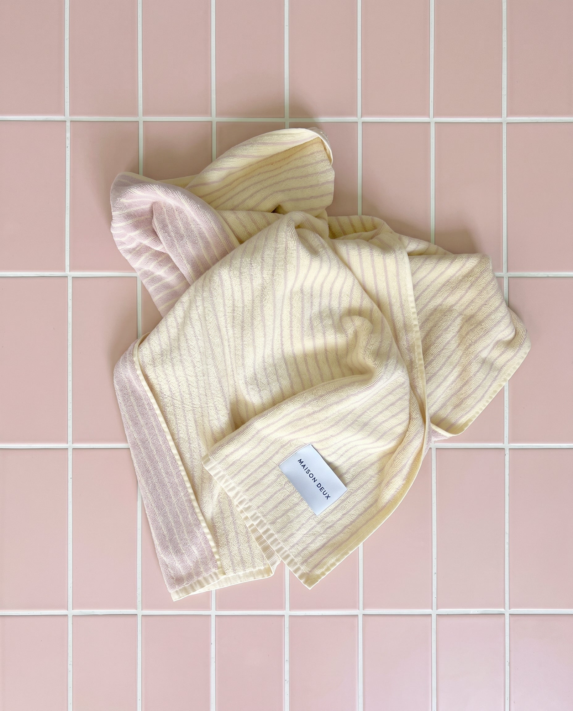 Butter yellow and pink striped towel styled in twisted wrap