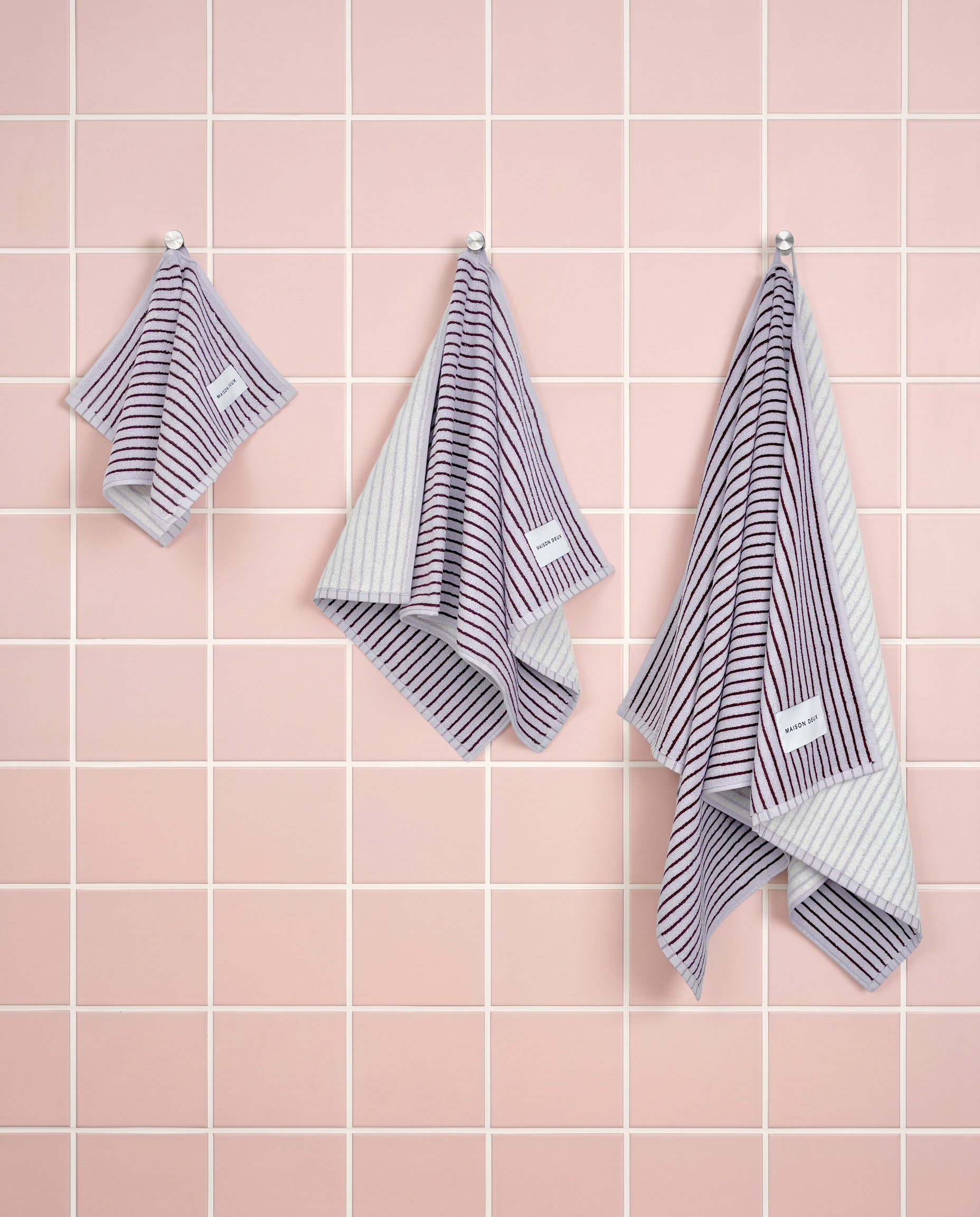 Lilac bordo striped organic cotton towels shown in guest, hand and bath sizes