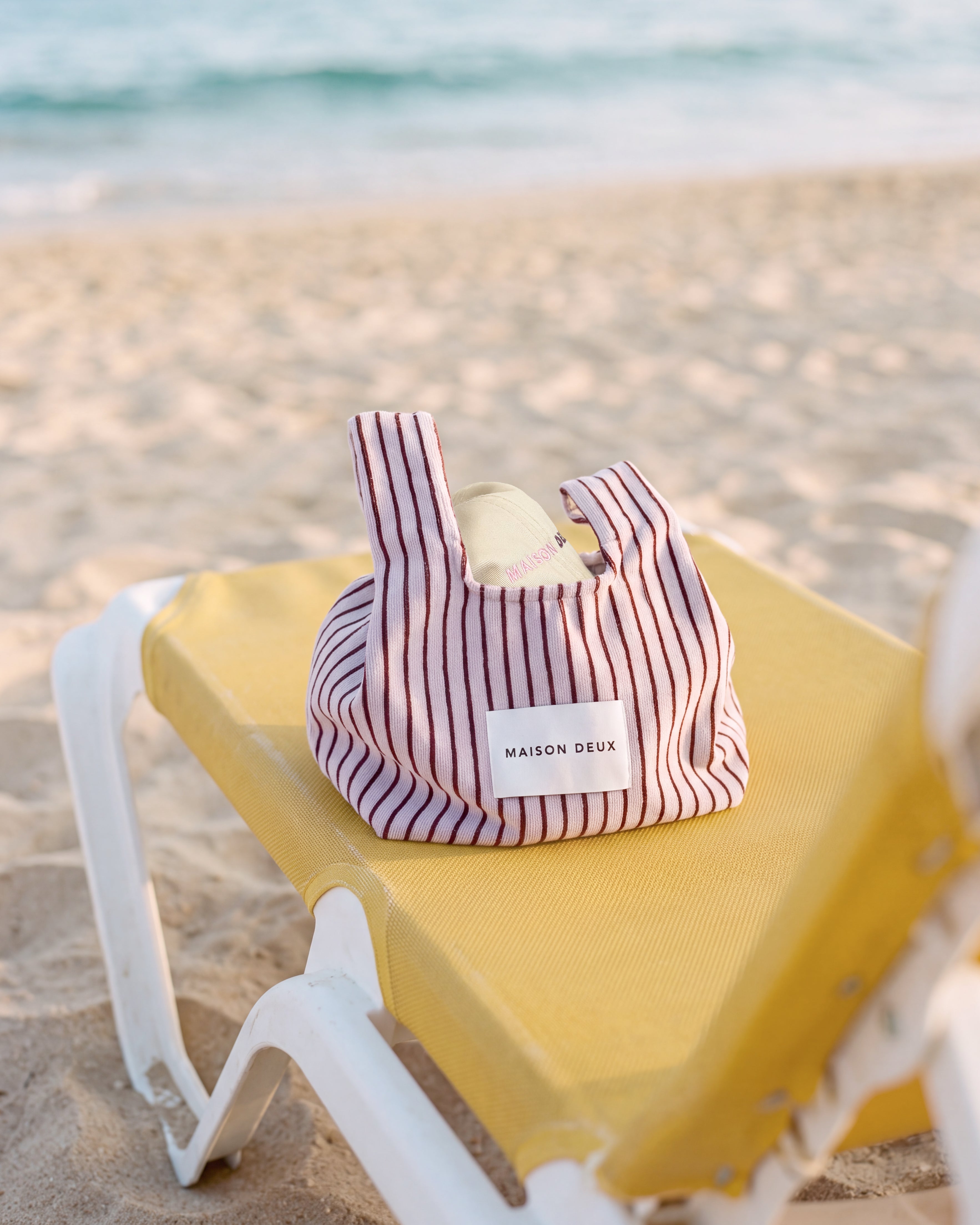 Lilac and bordo mini terry beach bag styled on sunbed